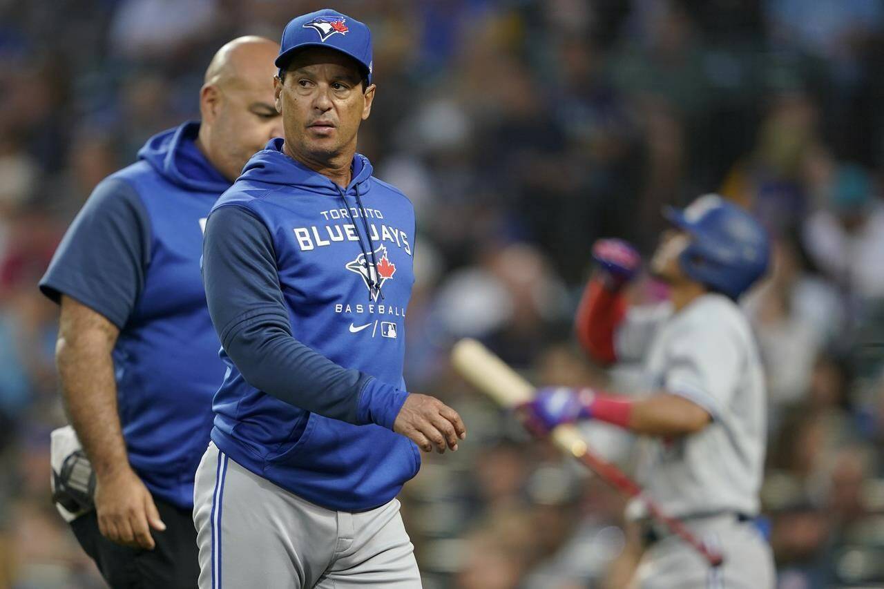 Toronto Blue Jays manager Charlie Montoyo walks with a trainer after Bradley Zimmer was hit by a pitch during the seventh inning of the team's baseball game against the Seattle Mariners on July 7, 2022, in Seattle. THE CANADIAN PRESS/AP, Ted S. Warren