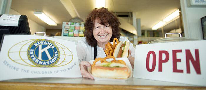 Jan Burns serves up lunch at the Oak Bay Kiwanis Tea Room where the service club hands out 500 free hot dogs this weekend to celebrate 75 years. (Black Press Media file photo)