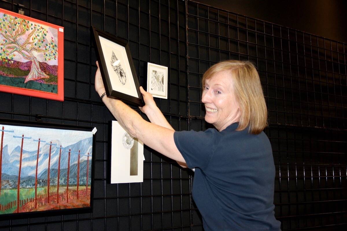 Elaine Thrale, a volunteer with the Sooke Fine Arts Show in 2017, hangs a painting in the show’s gift shop. Organizers say the show wouldn’t be possible without the hundreds of volunteers. (File-Sooke News Mirror)