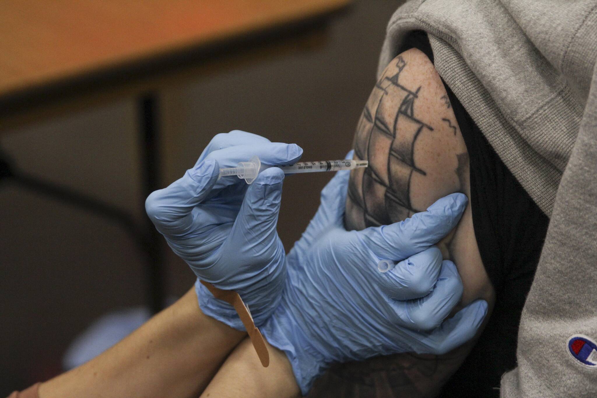 A nurse administers the coronavirus vaccine last year. (Michael S. Lockett / Juneau Empire)