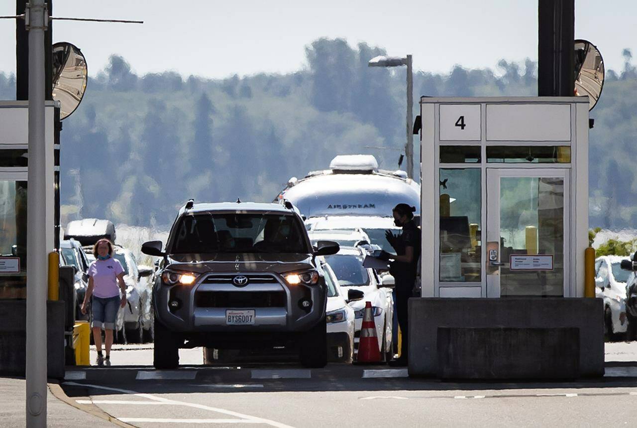 A Canada Border Services Agency officer speaks to a motorist entering Canada at the Douglas-Peace Arch border crossing in Surrey, B.C. on Monday, August 9, 2021. One-quarter of front line employees surveyed at Canada’s border agency said they had directly witnessed a colleague discriminate against a traveller in the previous two years. THE CANADIAN PRESS/Darryl Dyck