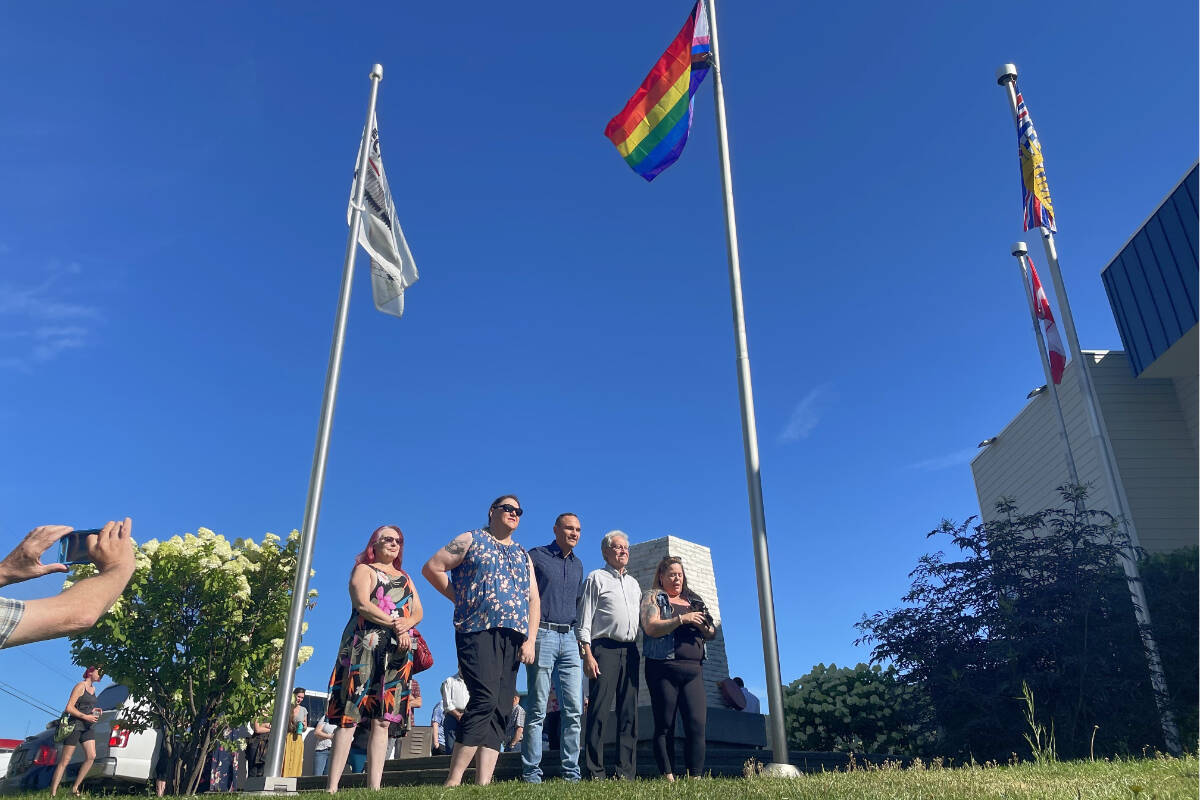 Charlotte Mortimer, from left, vice president Williams Lake Pride Society (WLPS), Billie Sheridan, secretary for WLPS, Williams Lake First Nation Chief Willie Sellars, Mayor Walt Cobb and Sonny Dyck, WLPS president, all stand under the newly raised Pride flag in front of city hall. (Ruth Lloyd photo - Williams Lake Tribune)