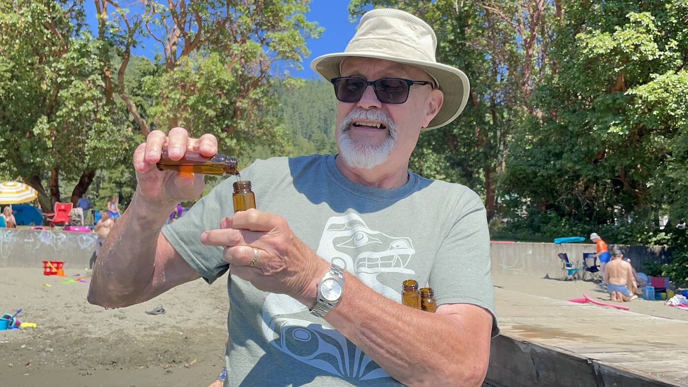 With two vials of lake water already collected, Jim Deck pours a vial of regular water into an empty vial to measure the amount of sunscreen in the air. (Sarah Simpson/Gazette)