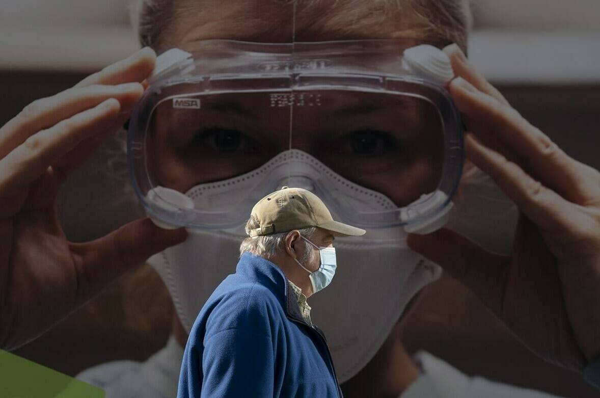 A man wears a protective face mask to help prevent the spread of COVID-19 as he walks past a billboard from the Vancouver General Hospital in Vancouver Thursday, April 8, 2021. THE CANADIAN PRESS/Jonathan Hayward
