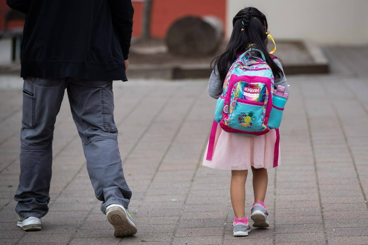 Avalynn Kwok, 4, walks with her dad, Manny Kwok, outside Lynn Valley Elementary School as her parents drop her off for her first day of kindergarten in North Vancouver on September 9, 2021. For years, Staples Canada has advertised back-to-school supplies to the tune of the “It’s the Most Wonderful Time of the Year,” with parents eager to see their children return to class after a busy summer. But back-to-school supplies can quickly add up, and parents already feeling the crunch from a rising cost of living may need to strategize how they approach this shopping season. THE CANADIAN PRESS/Darryl Dyck