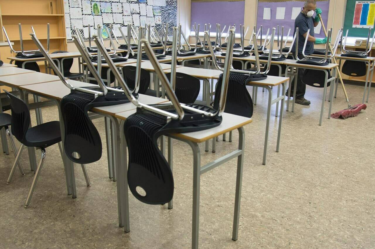 A cleaner helps clean a classroom at a school in Vancouver, B.C. Monday, March 23, 2020. A tentative framework agreement has been reached for 40,000 unionized elementary and secondary support staff in B.C. THE CANADIAN PRESS/Jonathan Hayward