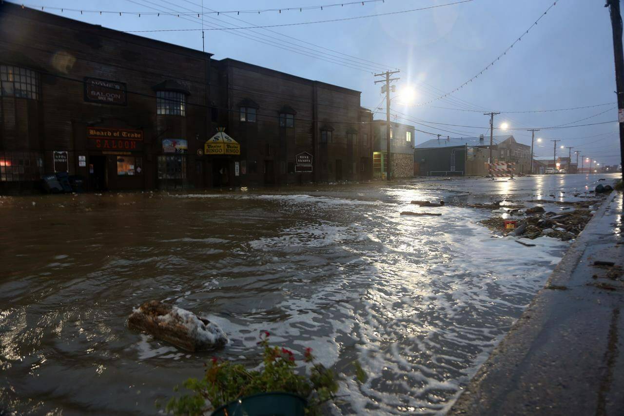 Water rushes down Front Street, just a half block from the Bering Sea, in Nome, Alaska, on Saturday, Sept. 17, 2022. Much of Alaska’s western coast could see flooding and high winds as the remnants of Typhoon Merbok moved into the Bering Sea region. The National Weather Service says some locations could experience the worst coastal flooding in 50 years. (AP Photo/Peggy Fagerstrom)