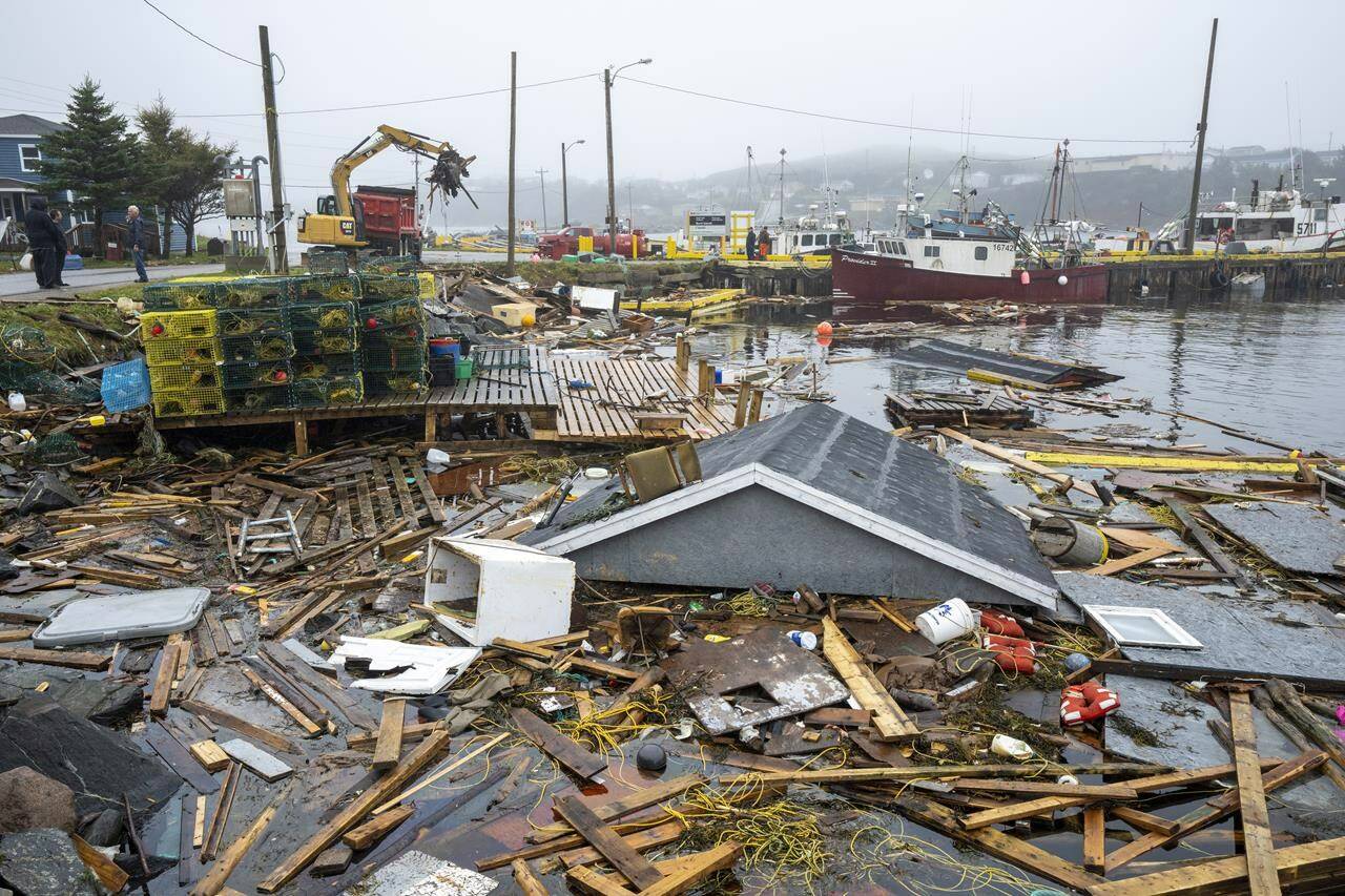 Heavy machinery clears up washed-up buildings and rubble in the harbour in Burnt Island, Newfoundland and Labrador on Tuesday, Sept. 27, 2022. Fiona left a trail of destruction across much of Atlantic Canada, stretching from Nova Scotia’s eastern mainland to Cape Breton, Prince Edward Island and southwestern Newfoundland. THE CANADIAN PRESS/Frank Gunn