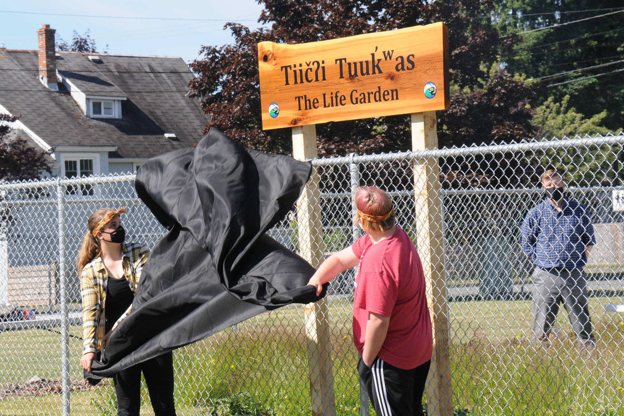 Students at Eighth Avenue Learning Centre in Port Alberni unveil the name of the school’s new garden during a ceremony on June 17, 2021. (SUSIE QUINN / ALBERNI VALLEY NEWS)