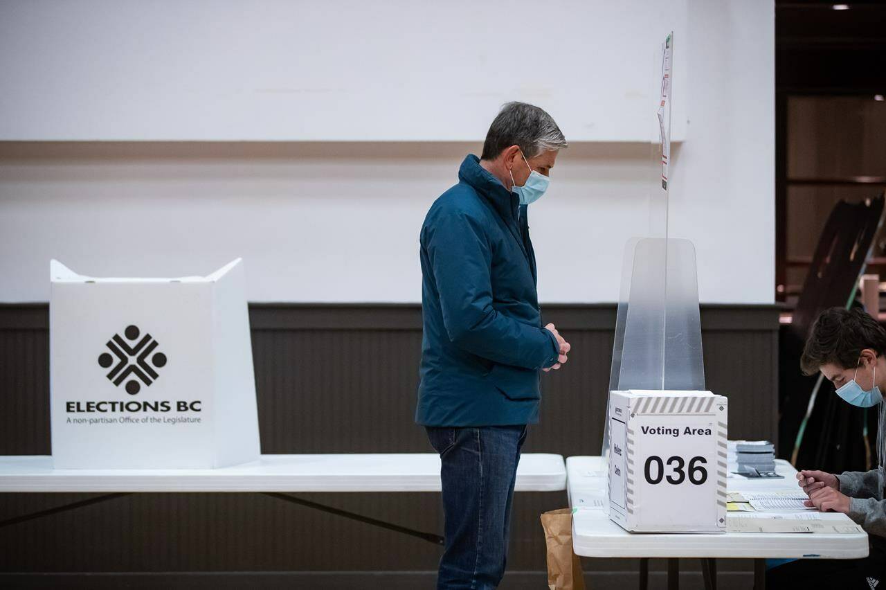 B.C. Liberal Leader Andrew Wilkinson waits as a polling station worker checks a list before being sent to a different ballot box to cast his vote for the provincial election in Vancouver on Saturday, October 24, 2020. British Columbia’s Electoral Boundaries Commission has released a preliminary report that recommends the creation of six new electoral districts, which would bring the total number of seats in the legislature to 93. THE CANADIAN PRESS/Darryl Dyck