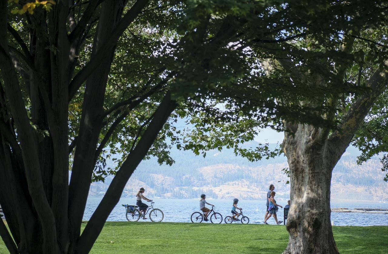 A family cycles along Lake Okanagan in Kelowna, B.C., Wednesday, Aug. 31, 2022.THE CANADIAN PRESS/Jeff McIntosh