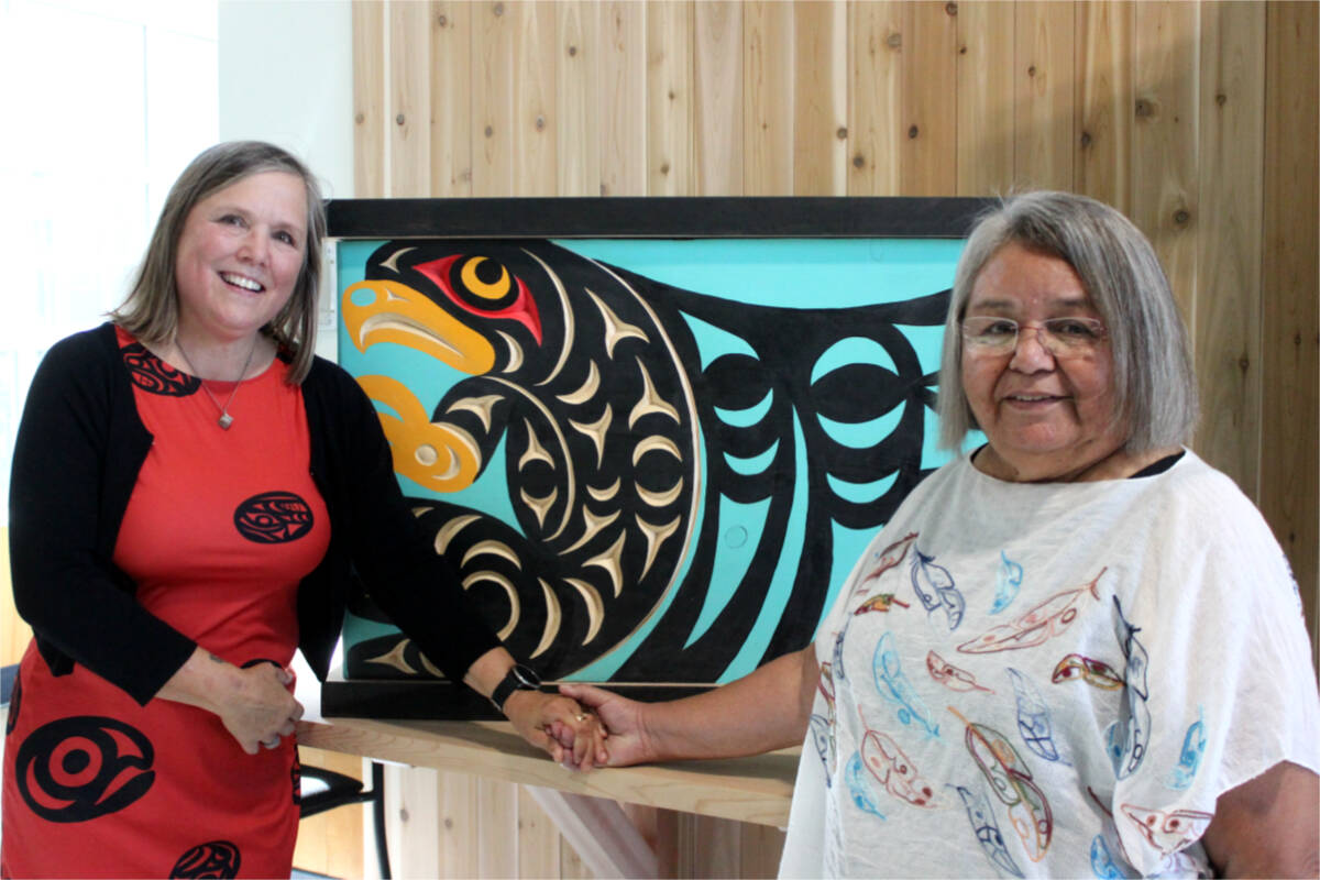 Diane Charles, principal, and Yutustana:t Mandy Jones, Snuneymuxw elder-in-residence at Ladysmith Secondary, pose in front of a wood box representing Coal Tyee Elementary’s name change to Syuẁén’ct Elementary School. (Karl Yu/News Bulletin)