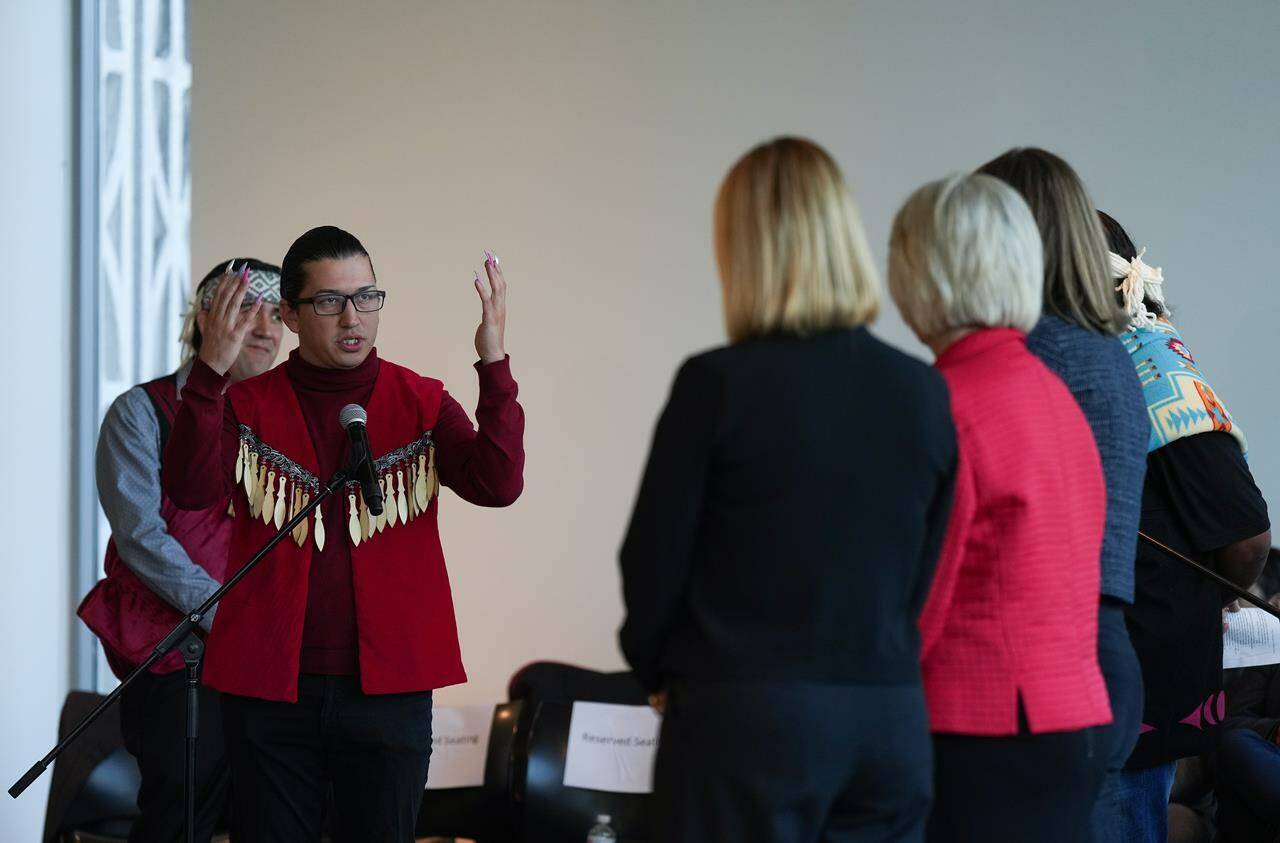 Squamish Nation councillor Khelsilem, left, raises his hands to incoming city councillors after presenting them with a copy of the United Nations Declaration on the Rights of Indigenous Peoples task force report in Vancouver, on Wednesday, October 19, 2022. The final report is a result of a partnership with the Musqueam Indian Band, Squamish Nation and Tsleil-Waututh Nation. According to the task force it is the first co-developed strategy between Indigenous nations and a municipal government in Canada. THE CANADIAN PRESS/Darryl Dyck