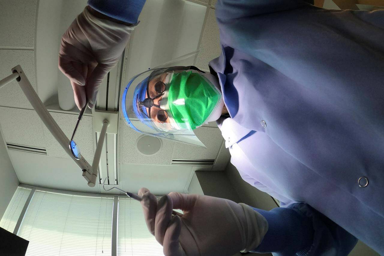 A dentist holds instruments in Skokie, Ill., on Friday, June 12, 2020. The House of Commons standing committee on health voted Monday night to adopt Bill C-31, sending it back to the House for a vote. THE CANADIAN PRESS/AP/Charles Rex Arbogast