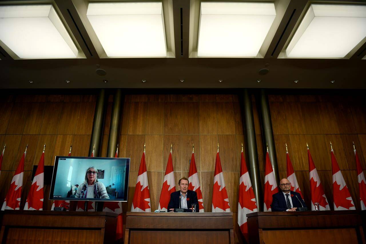 Minister of Crown-Indigenous Relations Marc Miller, centre, Minister of Justice David Lametti and and Minister of Indigenous Services Patty Hajdu, appearing via video conference at left, participate in a news conference regarding the order from the Canadian Human Rights Tribunal to compensate Indigenous children and their families, in Ottawa, on Friday, Oct. 29, 2021. THE CANADIAN PRESS/Justin Tang