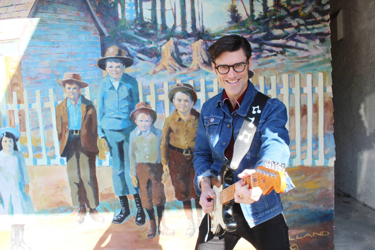 Zachary Stevenson stands out against the Chemainus murals on his return to town. (Photo by Don Bodger)