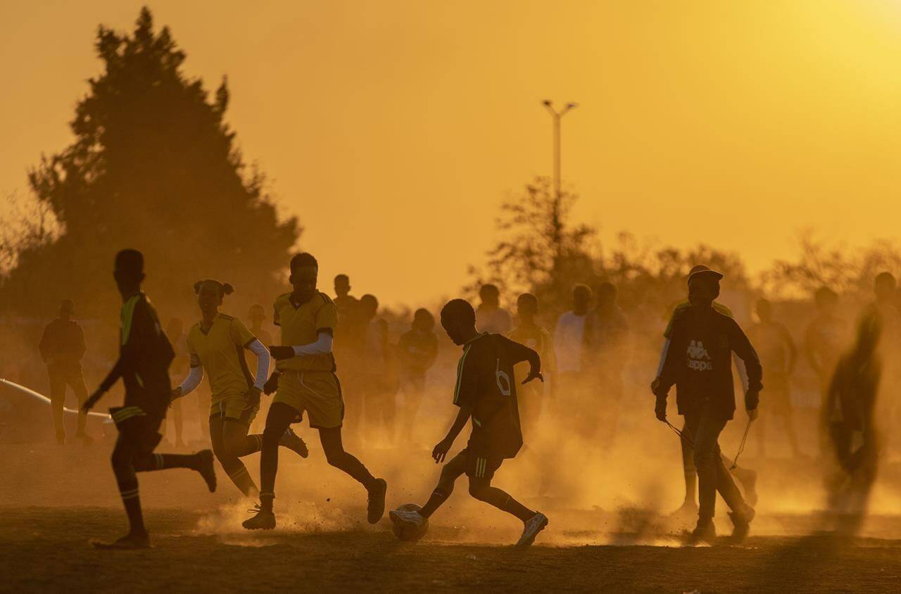 FILE- Young boys play soccer on a dusty field in Duduza, east of Johannesburg, South Africa, June 23, 2021. Soccer has embarked on probably its most ambitious global youth development program, an ultimate goal of delivering millions of soccer balls and a coaching program to 700 million children aged between 4 and 14 across the world. The Football For Schools project was launched in 2019 but came to a grinding halt because of the COVID-19 pandemic. It has now been relaunched. (AP Photo/Themba Hadebe, file)