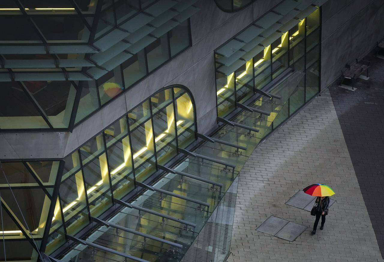 A pedestrian carries an umbrella as rain falls in Surrey, B.C., on Friday, October 21, 2022. Another atmospheric river is forecast to bring heavy rain to coastal British Columbia by late Thursday and this one could drench drought-stricken areas that didn’t see a lot of rain when the last storm rolled through. THE CANADIAN PRESS/Darryl Dyck