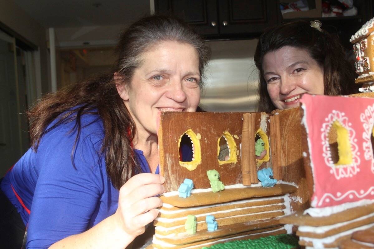 Margie Edwards, director of administrative services, left, and Cheryl Chalifour, executive director of Revera Parkwood Place with the magical Santa workshop and village the team is creating for the 14th annual Habitat for Humanity Victoria Gingerbread Showcase. (Christine van Reeuwyk/News Staff)