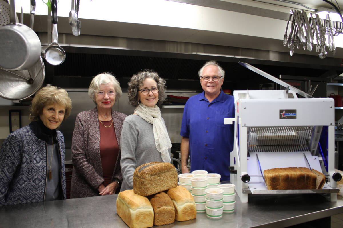 Volunteers and donors Maria Dominelli (from left), Mary Collins, Sheila Connelly and Richard Crow stand in front of the new bread slicer that will help the team from The Soup Kitchen put together sandwiches faster. (Hollie Ferguson/News Staff)
