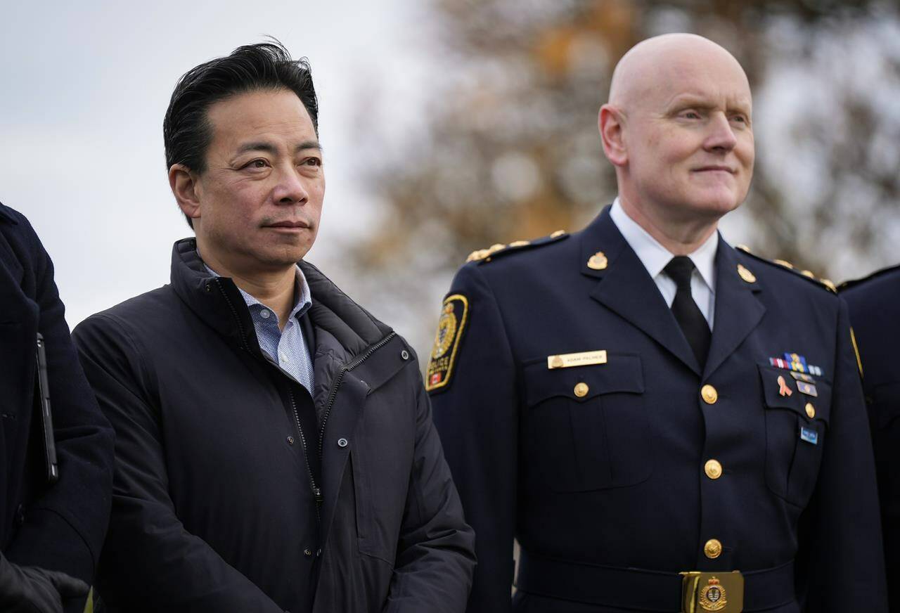 Vancouver Mayor Ken Sim, left, and Vancouver Police Chief Adam Palmer listen as B.C. Premier David Eby announces a new public safety plan in Vancouver on Sunday, November 20, 2022. THE CANADIAN PRESS/Darryl Dyck