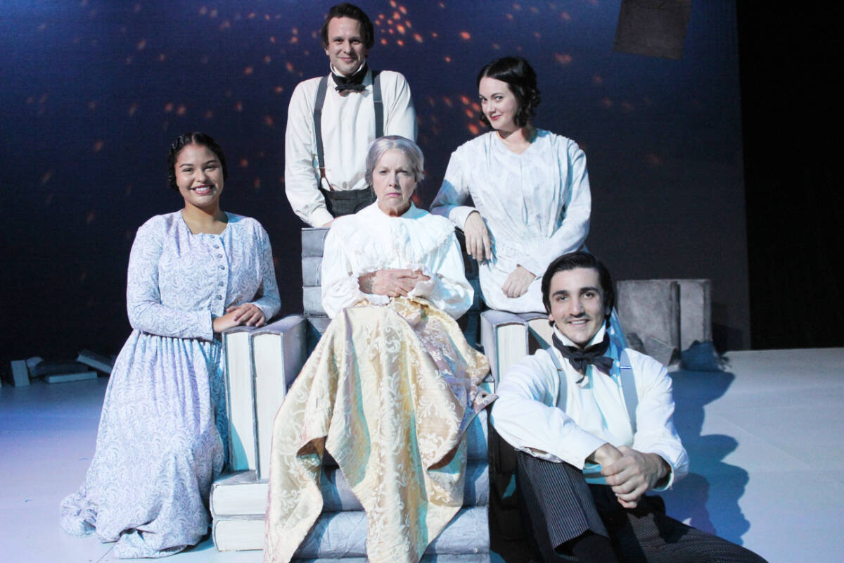 A grumpy Scrooge (Louise Phillips) is surrounded by happy cast members, from left: Yasmin D’Oshun, Jay Clift, Emma Slipp and Stephen Thakkar. (Photo by Don Bodger)