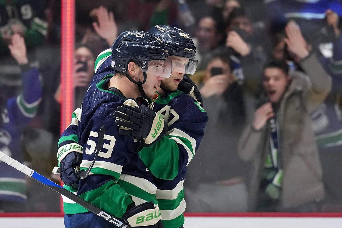 Vancouver Canucks’ Bo Horvat, front, and Elias Pettersson, of Sweden, celebrate Horvat’s goal against the Arizona Coyotes during the first period of an NHL hockey game in Vancouver, on Saturday, December 3, 2022. THE CANADIAN PRESS/Darryl Dyck