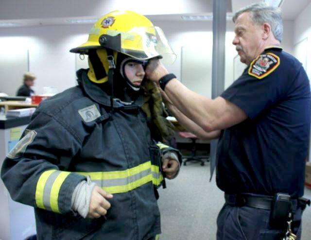 Rick McLeod helps a student suit up with firefighter gearin this file photo from 2012. McLerod has served more than 30myears with Sooke Fire Rescue. (File - Sooke News Mirror)