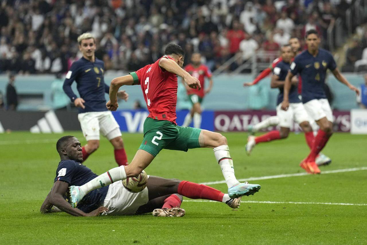 France’s Ibrahima Konate, left, challenges for the ball with Morocco’s Achraf Hakimi during the World Cup semifinal soccer match between France and Morocco at the Al Bayt Stadium in Al Khor, Qatar, Wednesday, Dec. 14, 2022. (AP Photo/Francisco Seco)