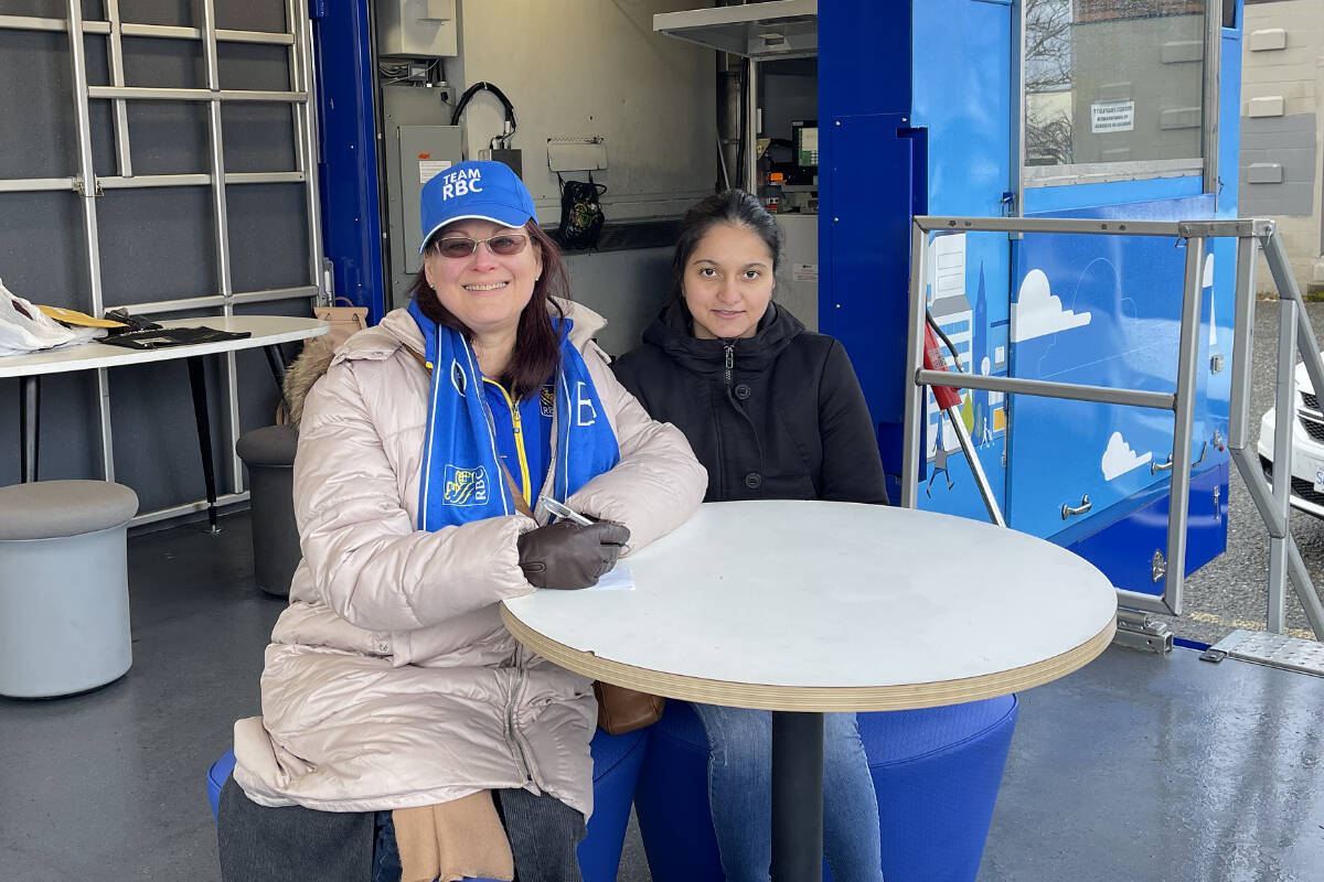 Client advisors Cynthia Gerbert, left, and Anshi Goswami from RBC Royal Bank prepare to talk with clients at the RBC Mobile Bank, set up at Fourth Avenue and Mar Street in Port Alberni. (SUSAN QUINN/ Alberni Valley News)
