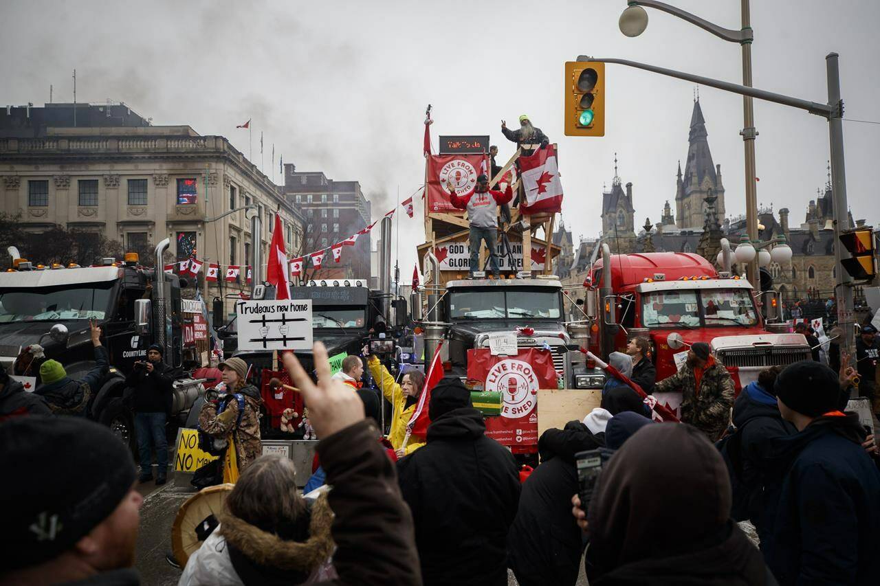 Protesters and supporters gather to listen to speakers in downtown Ottawa as a protest against COVID-19 measures that has grown into a broader anti-government protest continues to occupy Ottawa, Thursday, Feb. 17, 2022. The “Freedom Convoy” protest was chosen as The Canadian Press Newsmaker of the Year. THE CANADIAN PRESS/Cole Burston