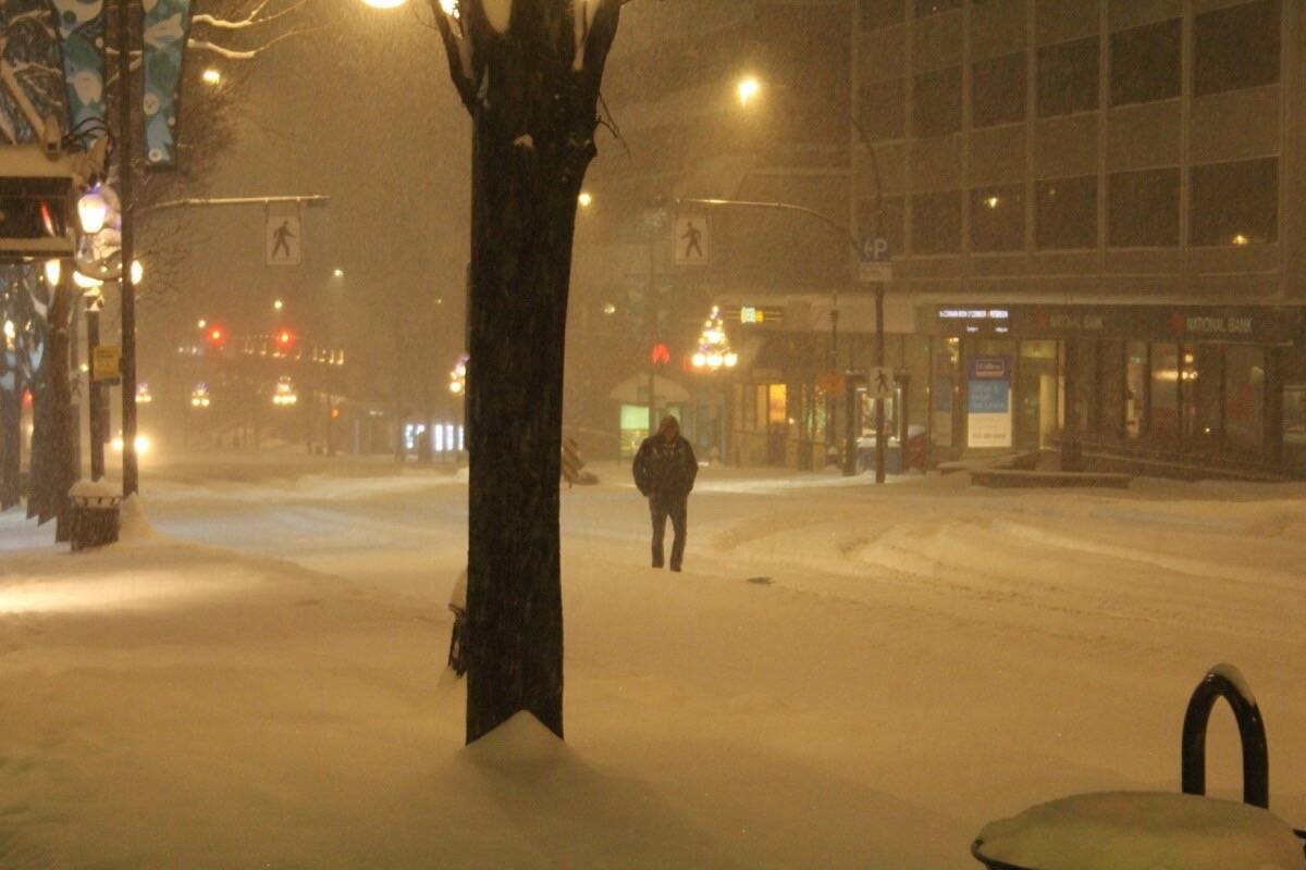 Blanshard and Douglas streets in Victoria remain snow-covered – as the white stuff continues to fall – with pedestrians resorting to the street as sidewalks predominantly remain uncleared as of 7 a.m. Dec. 20. (Christine van Reeuwyk/News Staff)