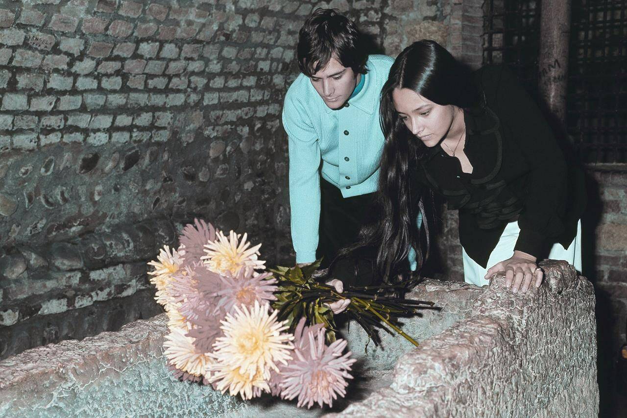 FILE - Olivia Hussey and Leonard Whiting, who are playing the title roles in Franco Zeffirelli’s “Romeo and Juliet,” place flowers on the “Tomba di Giulietta”, or the Tomb of Juliet, in Verona, northern Italy, on Oct. 22, 1968. The two stars of 1968’s “Romeo and Juliet” sued Paramount Pictures for more than $500 million on Tuesday, Jan. 3, 2023, over a nude scene in the film shot when they were teens. (AP Photo/File)