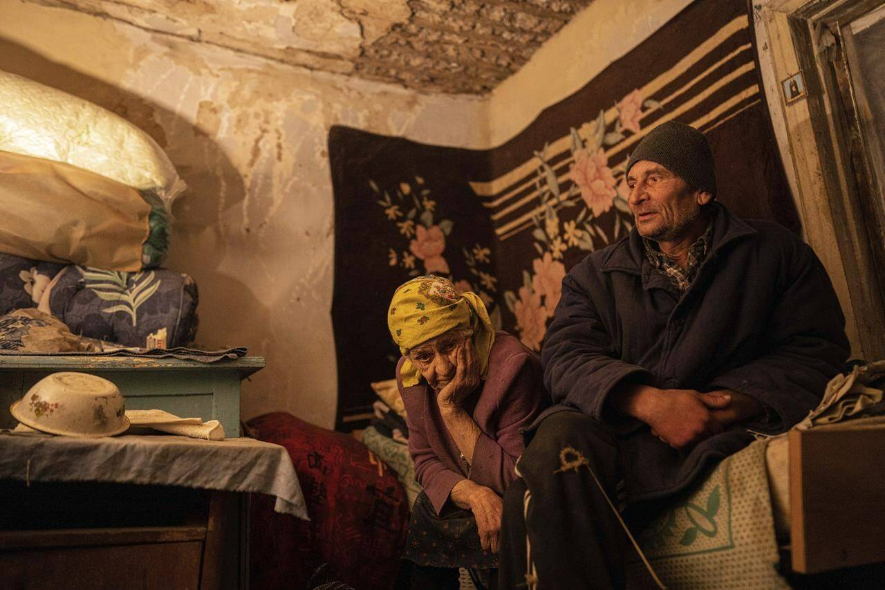Nina Gonchar, 93, and her son Mykola Gonchar, 58, sit inside their house which was mostly destroyed by Russian forces in the recently retaken village of Bogorodychne, Ukraine, Saturday, Jan. 7, 2022. Gonchar’s son Vasyliy and his wife Liubov were killed by Russian shelling on July 10, 2022. (AP Photo/Evgeniy Maloletka)