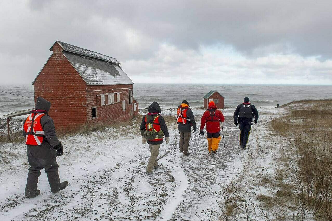 Members of a ground search and rescue team walk along the shore of the Bay of Fundy in Hillsburn, N.S. as they look for five fishermen missing after the scallop dragger Chief William Saulis sank in the Bay of Fundy, on Wednesday, Dec. 16, 2020. As Canadian fishers continue to die in frigid waters when their boats capsize, a debate is surfacing over why clear rules aren’t in place to ensure basic stability of vessels that face ocean storms.THE CANADIAN PRESS/Andrew Vaughan