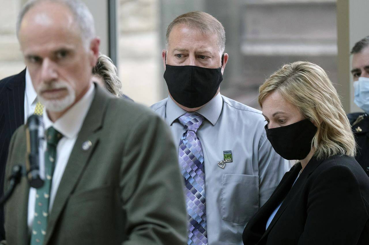 FILE - Cory and Shari Foltz, the parents of a Bowling Green State University student who died in an alleged hazing incident, look on while Wood County Prosecuting Attorney Paul Dobson, left, takes questions from the media at the Wood County Courthouse, April 29, 2021, in Bowling Green, Ohio. The family of the student will receive nearly $3 million from Bowling Green State University to settle its lawsuit. A copy of the agreement announced Monday, Jan. 23, 2023 says the family of Stone Foltz and the university will work together to eliminate hazing on college campuses. (J.D. Pooley/Sentinel-Tribune via AP, Fille)