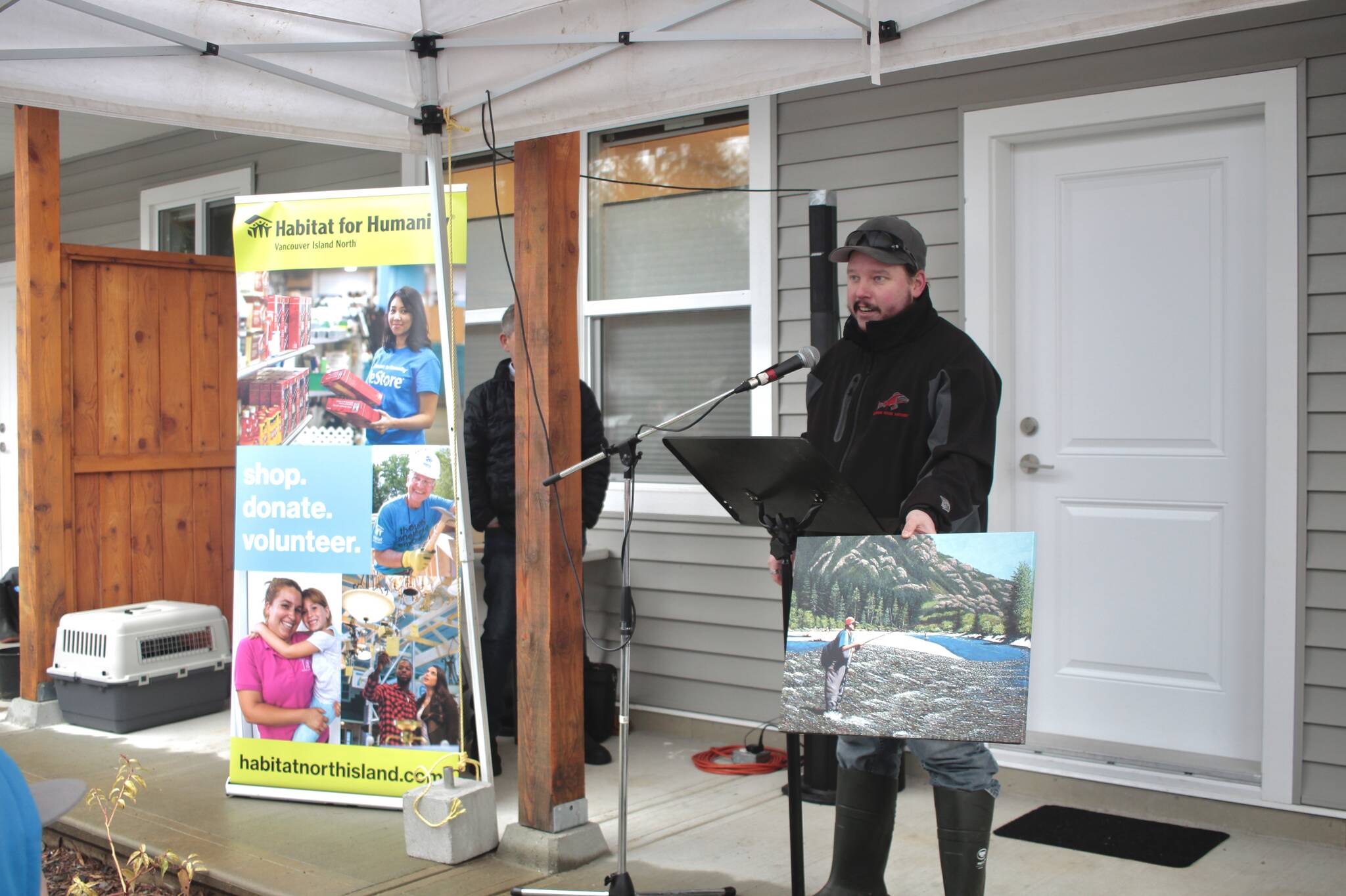 Sean Babchuk holds up a painting that he can finally hang in his new home. Photo by Marc Kitteringham/Campbell River Mirror