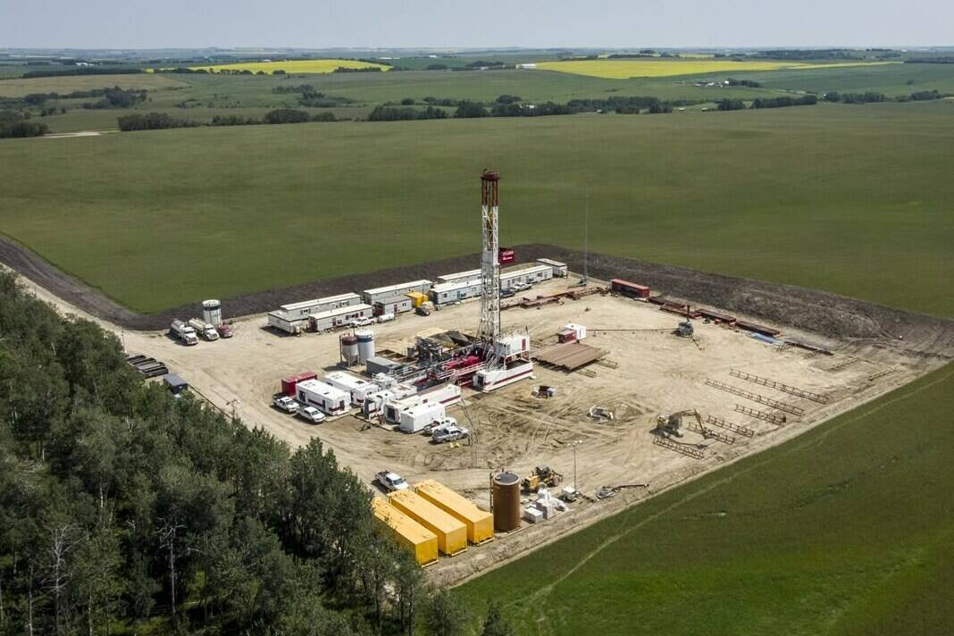 An oil drilling rig operates surrounded by canola and hay fields near Cremona, Alta., Monday, July 12, 2021. Canada’s long-promised plan to transition its labour force to respond to climate change says a clean energy economy will not lead to massive unemployment. THE CANADIAN PRESS/Jeff McIntosh