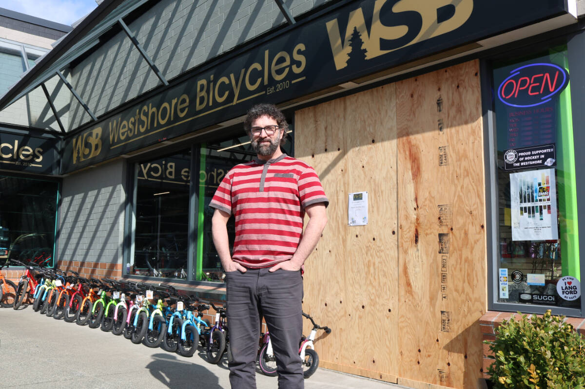 Chris Dickinson, owner of WestShore Bicycles in front of his store where the door was broken by a truck during a break-in. (Bailey Moreton/News Staff)