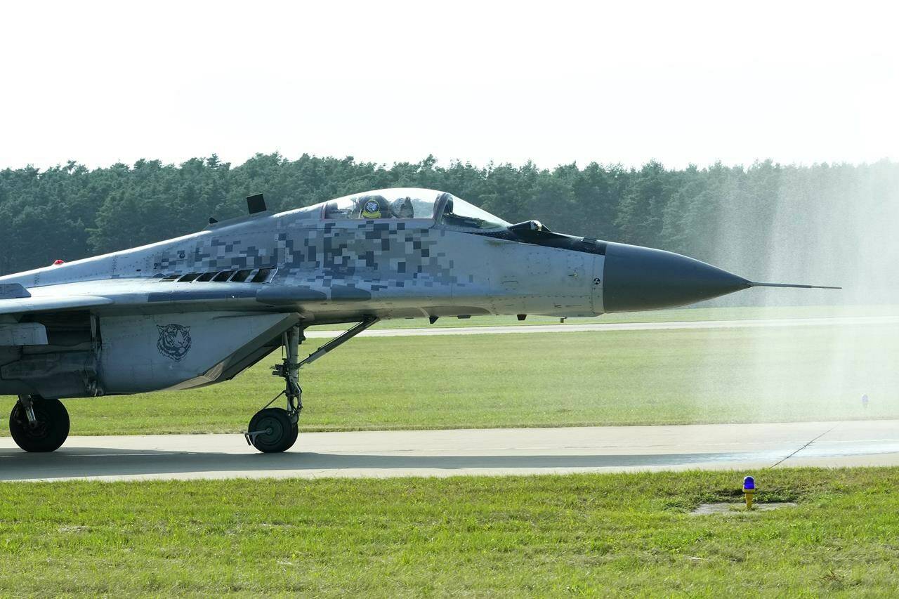 FILE - Slovak Air Force MiG-29 goes through a water gate during an airshow in Malacky, Slovakia, Saturday, Aug. 27, 2022. On Friday March 17, 2023 Slovakia’s government has approved a plan to give Ukraine its fleet of 13 Soviet-era MiG-29 fighter jets, becoming the second NATO member country to agree to fulfill the Ukrainian government’s pleas for warplanes to help defend against Russia’s invasion. (AP Photo/Petr David Josek,File)