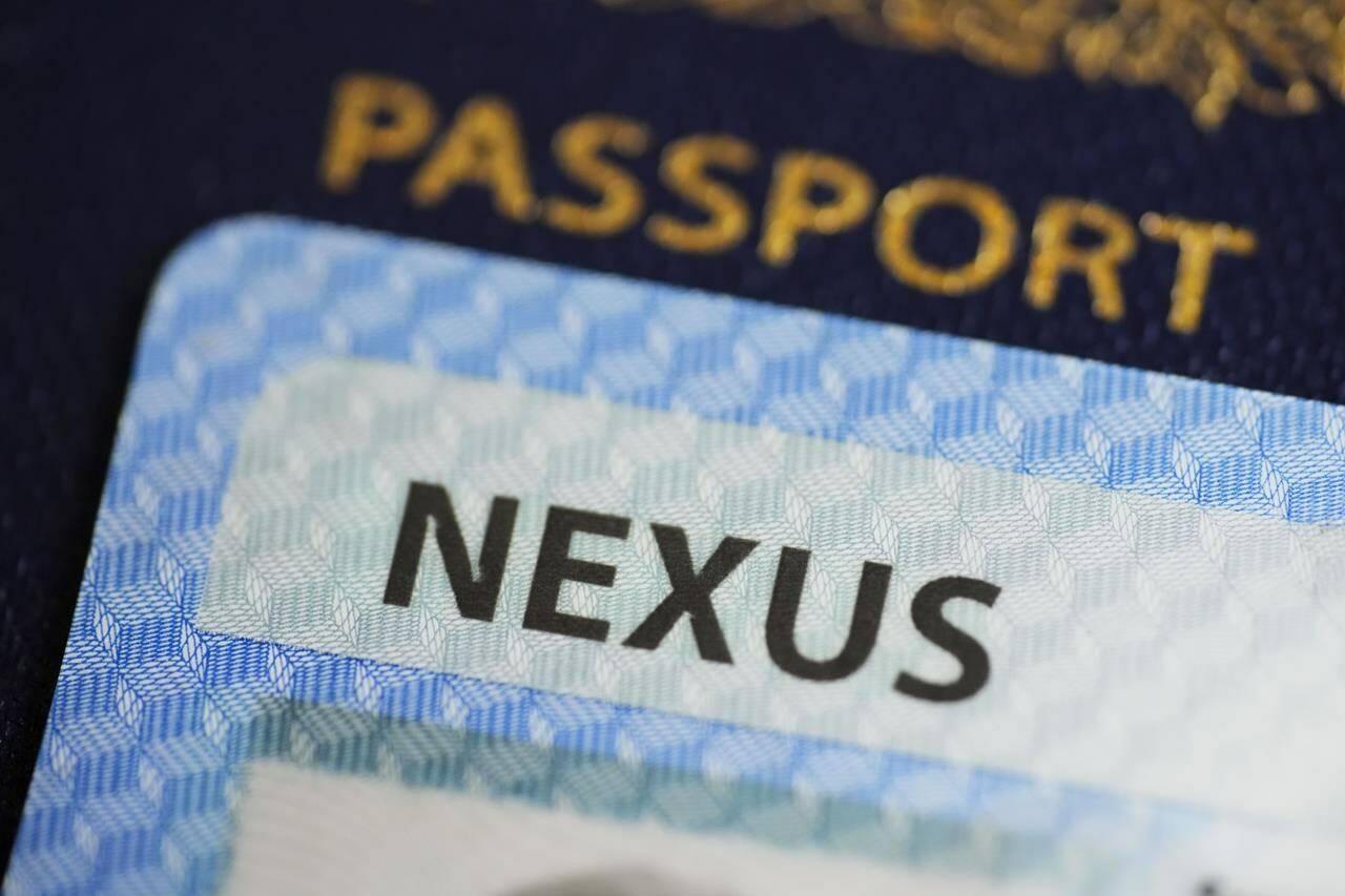 A NEXUS card and a Canadian passport are pictured in Ottawa on Tuesday, Jan. 17, 2023. The federal government says the Nexus trusted-traveller program will fully ramp back up within five weeks, allowing frequent border crossers to complete their applications and speed up their trips. THE CANADIAN PRESS/Sean Kilpatrick