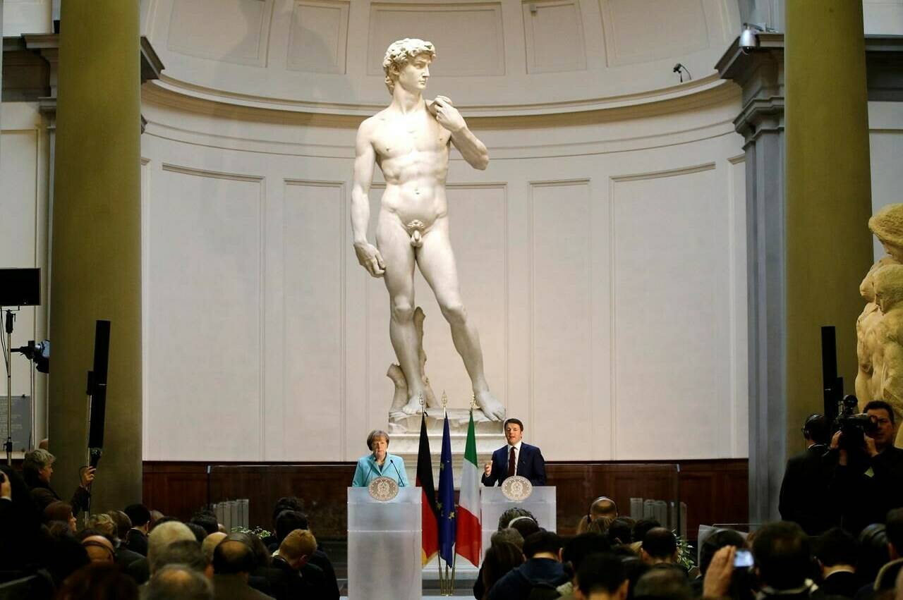 FILE - German Chancellor Angela Merkel, left, and Italian Prime Minister Matteo Renzi speak during a press conference in front of Michelangelo's "David statue" after their bilateral summit in Florence, Italy, on Jan. 23, 2015. The head of Florence’s Galleria del’Accademia on Sunday March 26, 2023 invited the parents and students of a Florida charter school to visit and see Michelangelo’s “David,” after the school principal was forced to resign following parental complaints that an image of the nude Renaissance masterpiece was shown to a sixth-grade art class. (AP Photo/Antonio Calanni, File)