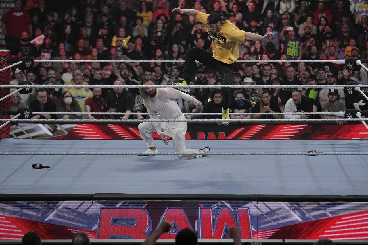 Wrestler Logan Paul, right, kicks Seth “Freakin” Rollins during the WWE Monday Night RAW event, Monday, March 6, 2023, in Boston. WWE’s WrestleMania arrives this weekend, Saturday, April 1, to a massive audience and vastly larger advertising revenue as it seeks to establish itself as a serious contender for major advertising bucks. (AP Photo/Charles Krupa)