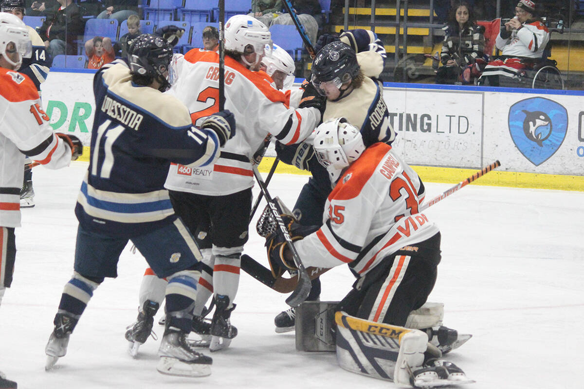 Langley Rivermen players Nick Messina, left, and Nicklas Hoogendoorn crash the front of the net as Nanaimo Clippers player Michael Craig defends on the play in front of goalie Aidan Campbell. (Karl Yu/News Bulletin)