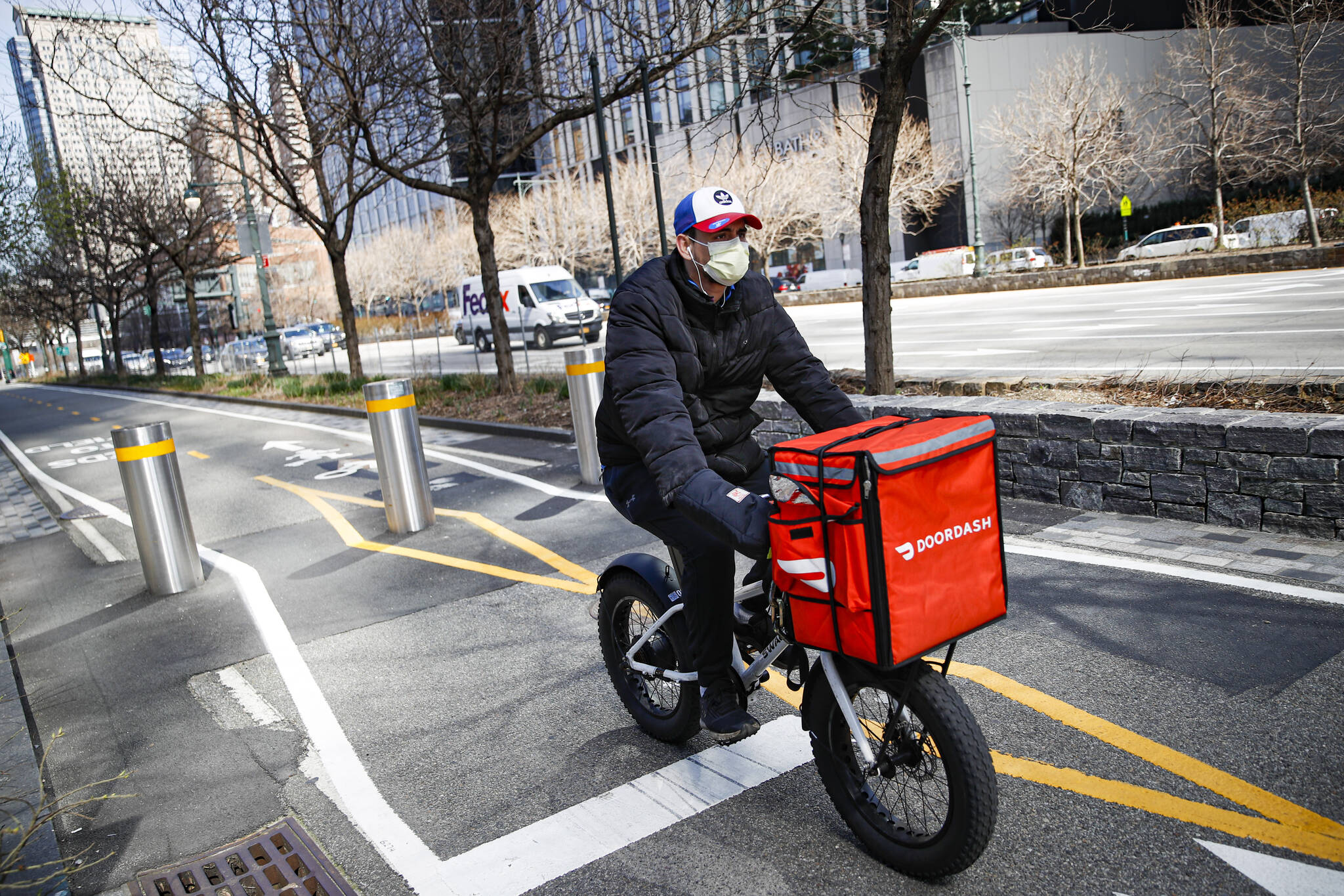In this March 16, 2020 file photo, a delivery worker rides his bicycle in New York. In B.C., the government conducted a series of engagements from November 2022 to January 2023 to better understand the concerns ride-hail and food-delivery workers have. (AP Photo/John Minchillo, File)