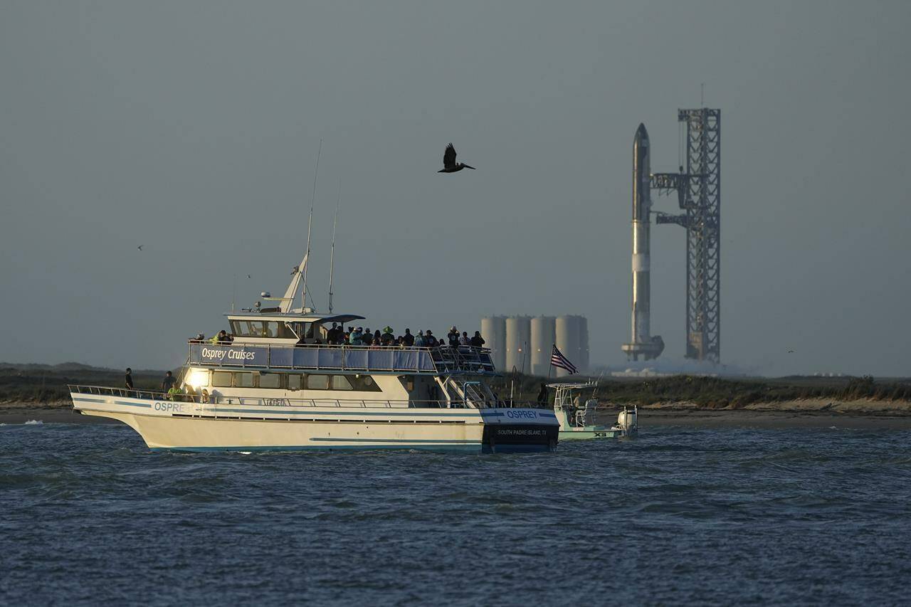 A boater passes SpaceX’s Starship, the world’s biggest and most powerful rocket, as it prepares to lift off from Starbase in Boca Chica, Texas,, Monday, April 17, 2023. (AP Photo/Eric Gay)