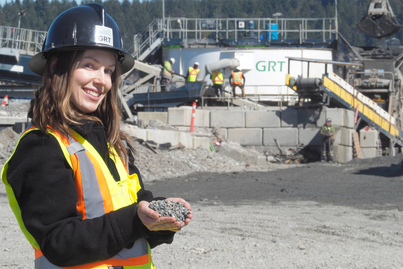 Dee Woods, GRT communications director, holds a small sample of product reclaimed from the company’s massive washing machine that separates contaminants from soil trucked to the Duke Point site. (Chris Bush/News Bulletin)