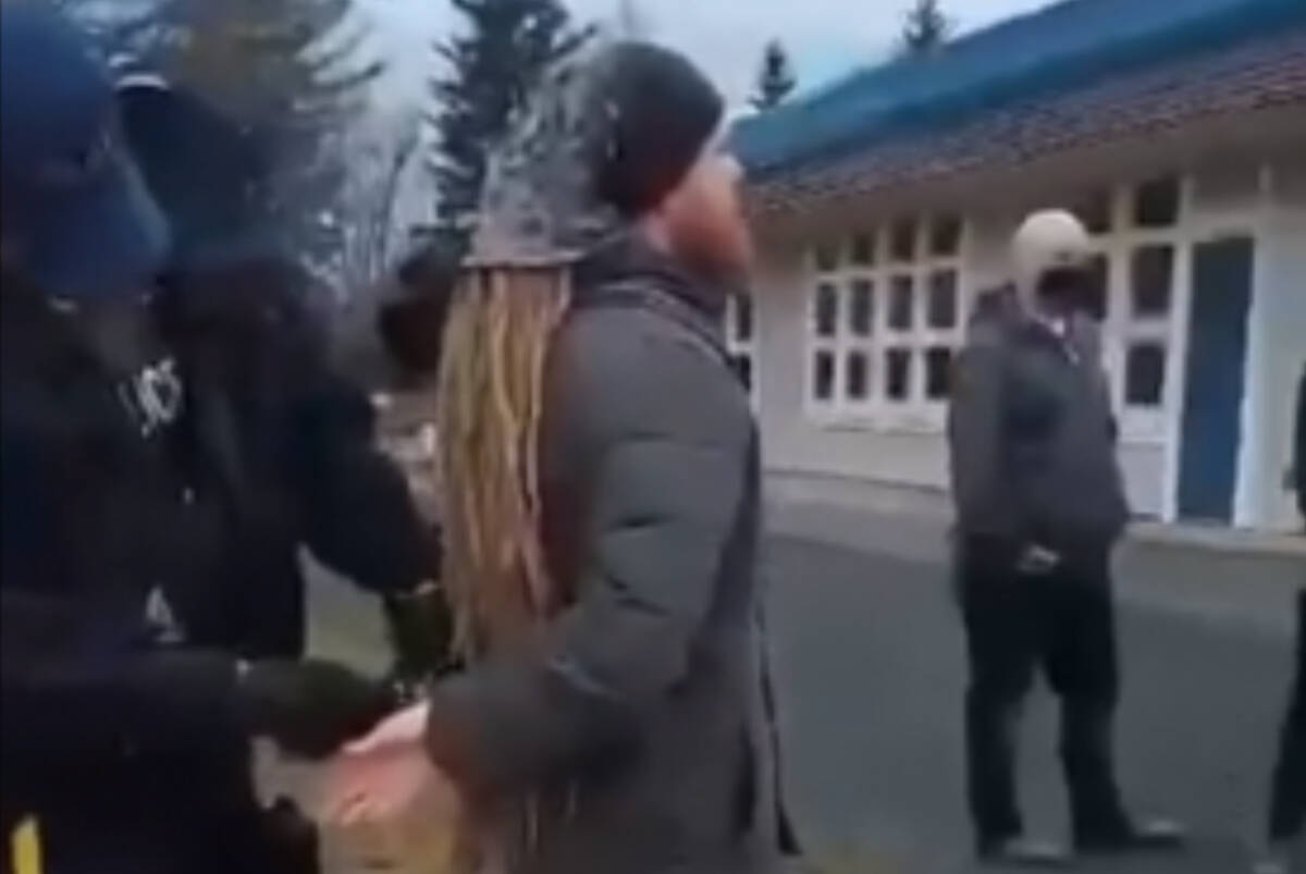A still of a video of Mark Alexander Van Heek being handcuffed by an RCMP officer on Sardis Elementary school grounds on Feb. 8, 2022. (Facebook)