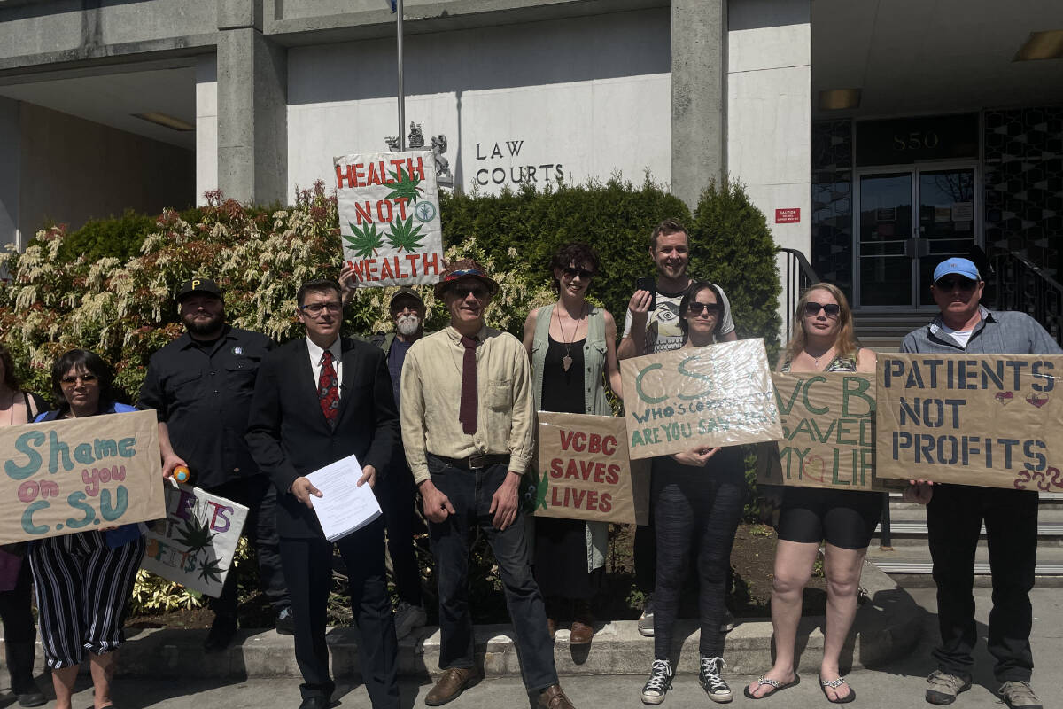 Ted Smith, the founder of the Victoria Cannabis Buyers Club and the club’s lawyer Kirk Tousaw, stand with supporters outside of the Victoria courthouse prior to filing a lawsuit against the province. (Hollie Ferguson/News Staff)