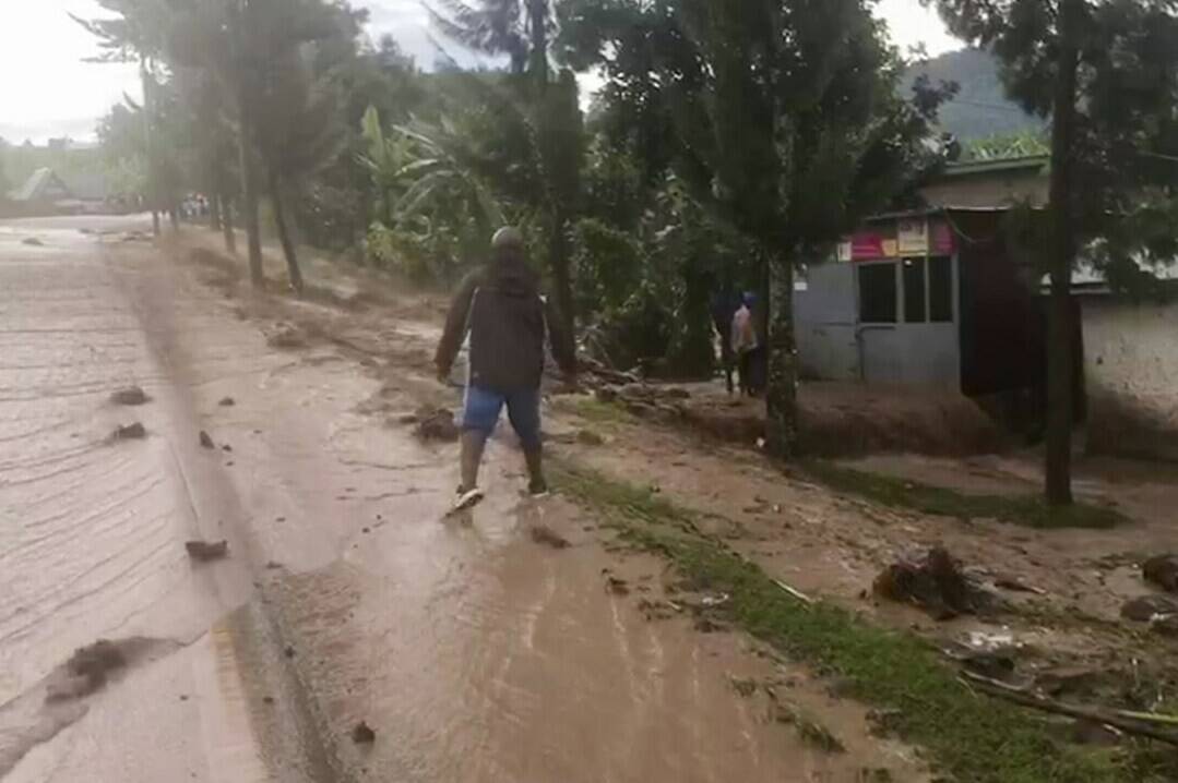 A man walks through floodwaters in western Rwanda on Tuesday, May 2, 2023. A public broadcaster in Rwanda says at more than 100 people have been killed in flooding amid torrential rain in the western and northern provinces of the country. (RwandaTV via AP)